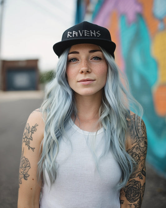 Junge Frau trägt die Ravens Snapback in Schwarz mit 3D-Puff-Stickerei RAVENS vor einer Graffiti-Wand